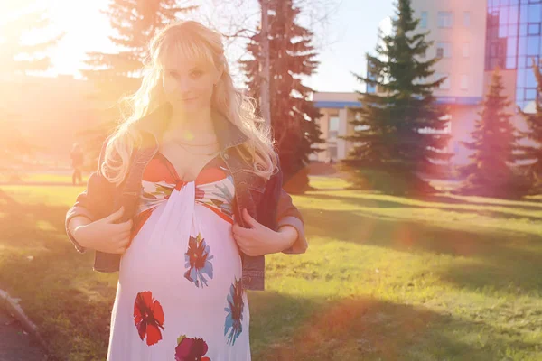 Hamile kız parkta bir yürüyüş. CI karnından kızla