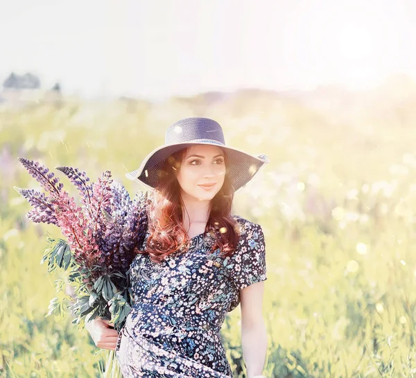 Ragazza incinta in un campo con fiori — Foto Stock