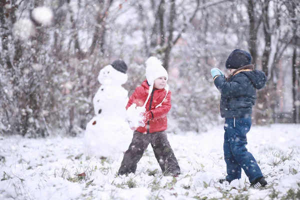 Les enfants marchent dans le parc première neige — Photo