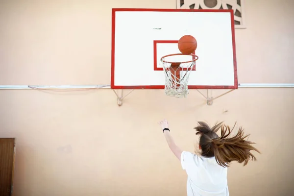 Flicka i gymmet spela en basket — Stockfoto