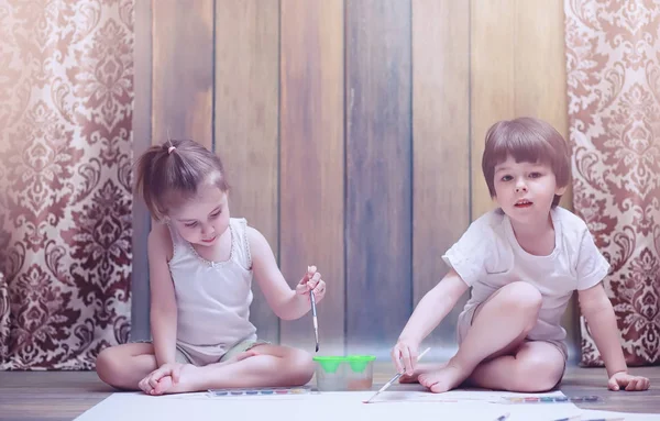 Little children paint on a large sheet of paper — Stock Photo, Image