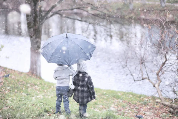 I bambini camminano nel parco prima neve — Foto Stock