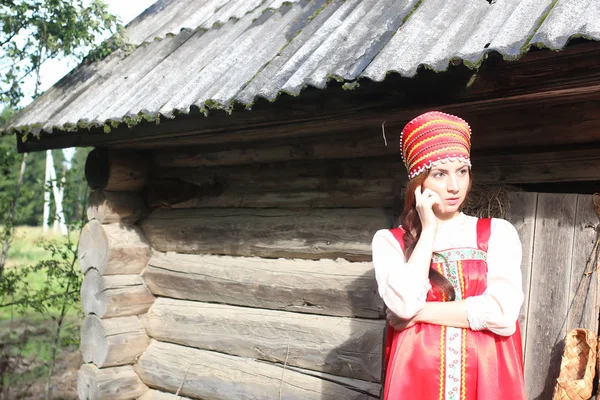 Girl in traditional dress wooden wall — Stock Photo, Image