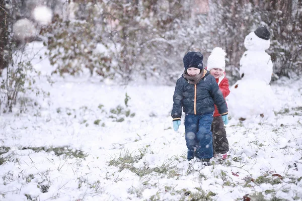 Barn vandring i parken första snön — Stockfoto