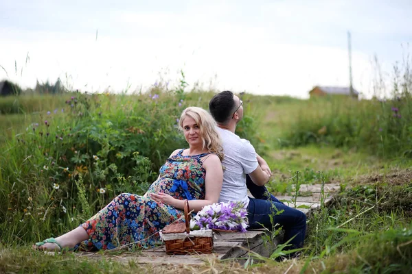 Fille enceinte avec gros ventre et jeune homme en plein air — Photo
