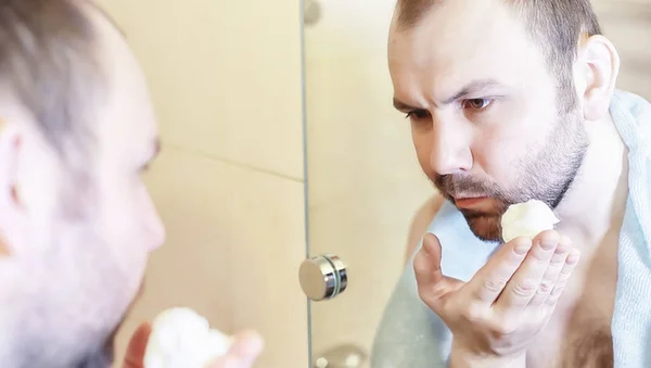 A man shaves in the bathroom in the morning — Stock Photo, Image