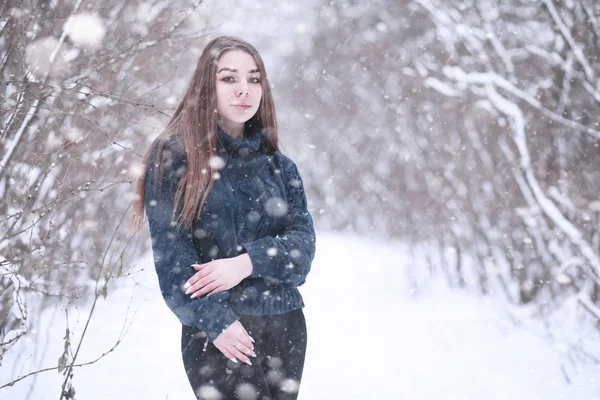 Fille dans un parc d'hiver en chute de neige — Photo