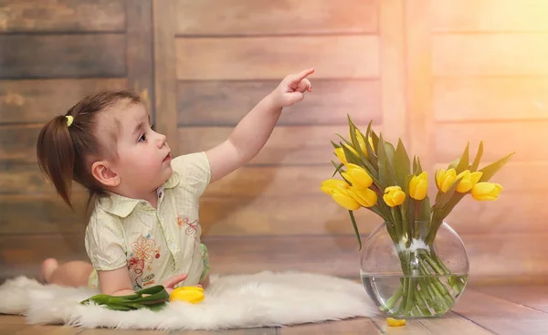 Malé dítě s kyticí žlutých tulipánů. Chlapec s dárkem — Stock fotografie