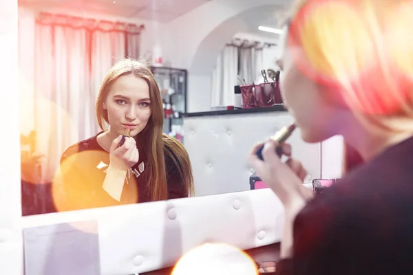 En ung flicka gör make-up i en skönhetssalong. Flickan i receptionen o — Stockfoto