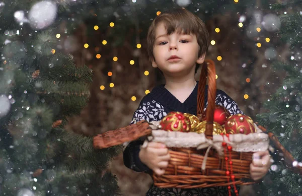 Un niño pequeño junto al árbol de Año Nuevo. Los niños decoran el Chris Fotos de stock libres de derechos