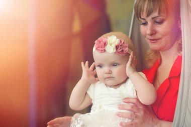 Kızın kollarında bir bebek. Anne çocuğunu kollarında tutuyor. Mutlu bir anne ve küçük bir bebek