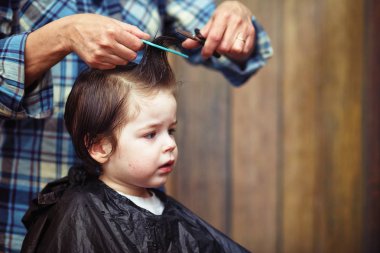 Küçük bir çocuk kuaförde kesilmiş. 