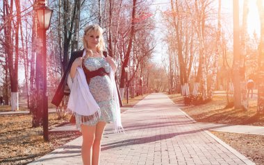 Hamile kız parkta bir yürüyüş. CI karnından kızla