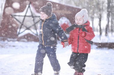 Çocuklar parkta ilk kar yürümek