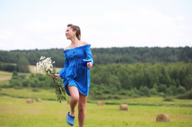 Genç tatlı kız bir alanda gün batımında koşmak