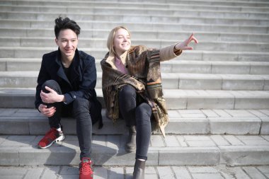 Bir kaç arkadaş basamaklarında oturan