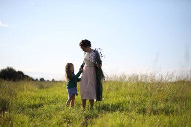 Anne ve kızı yolda yürüyor.