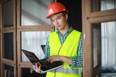 Kask ve inşaat koruyucu yelek Asyalı adam