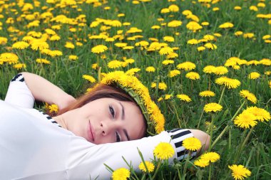 Sarı dandelions çayırda güneşli bir dinlenme kız