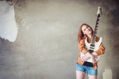 Kızıl saçlı kız bir elektro gitar ile. Rock müzisyen GIR