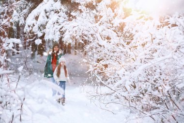 Genç bir aile yürüyüşe çıktı. Anne ve kızı şarapla yürüyorlar.