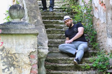 Adam terk edilmiş merdivenlerde oturuyor.