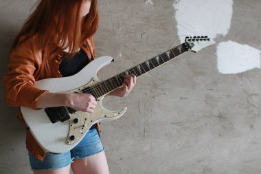 Kızıl saçlı kız bir elektro gitar ile. Rock müzisyen GIR