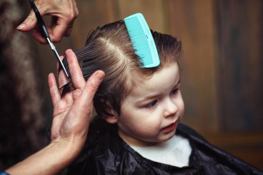 Küçük bir çocuk kuaförde kesilmiş. 