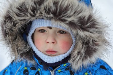Çocuklar kışın bahçede karla oynuyorlar.