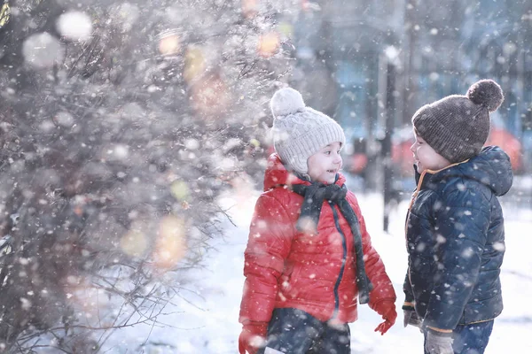 Les enfants marchent dans le parc première neige — Photo