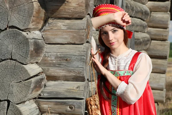 Chica en vestido tradicional pared de madera — Foto de Stock