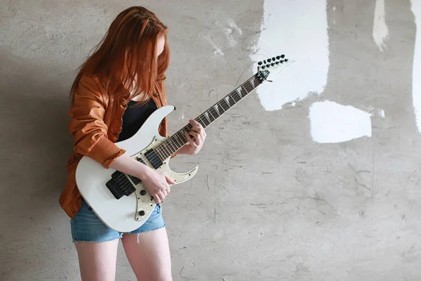 Menina ruiva jovem com uma guitarra elétrica. Músico de rock gir — Fotografia de Stock