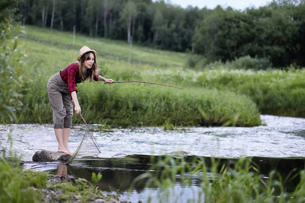 Ragazza vicino al fiume con una canna da pesca — Foto Stock