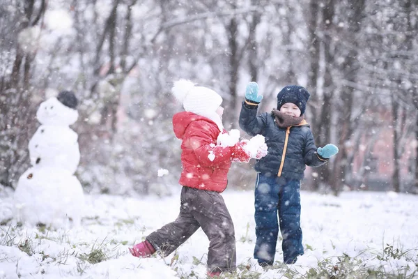 Les enfants marchent dans le parc première neige — Photo