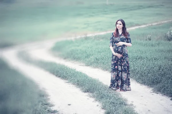 Schwangere Mädchen in einem Kleid in der Natur — Stockfoto