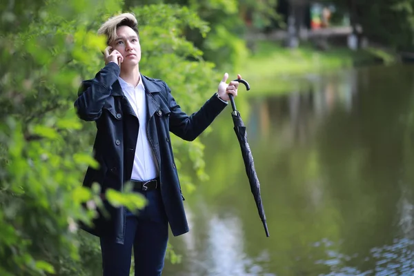 Primavera tempo piovoso e un giovane uomo con un ombrello — Foto Stock
