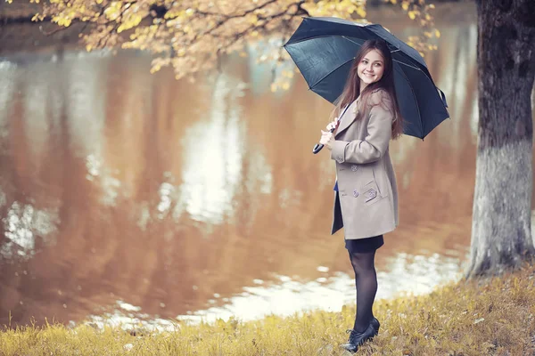 Herbstliches Regenwetter und ein junger Mann mit Regenschirm — Stockfoto