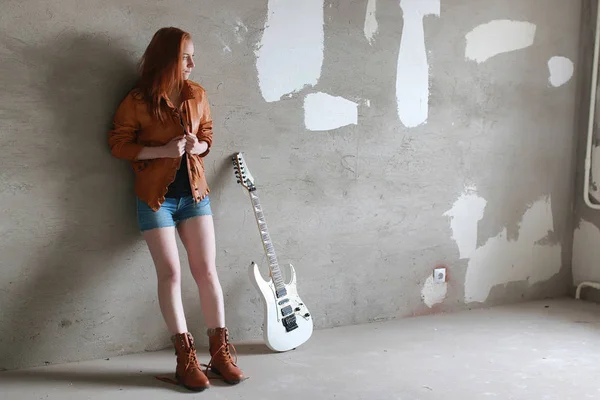 Menina ruiva jovem com uma guitarra elétrica. Músico de rock gir — Fotografia de Stock