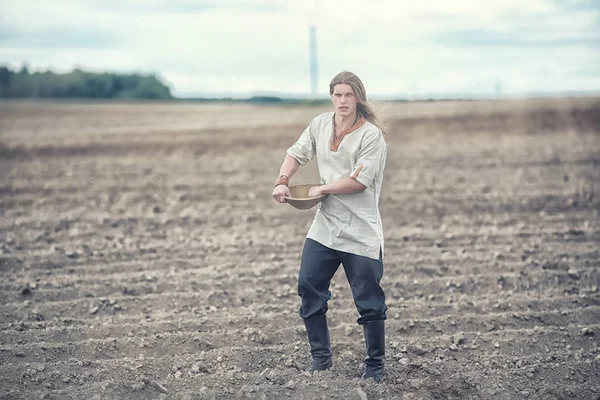 A young peasant sows the field with grain — Stock Photo, Image