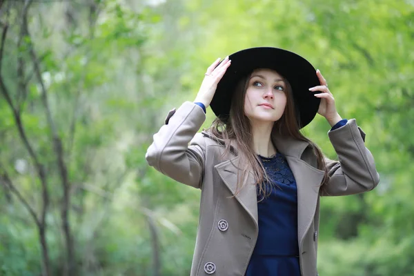Jeune fille dans un manteau dans un parc de printemps — Photo