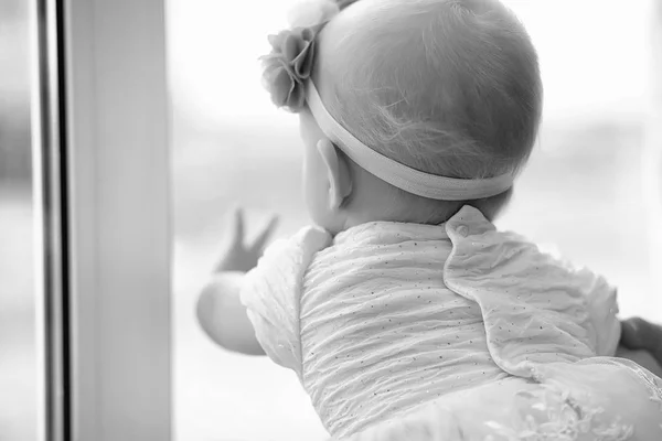 Kind im Kinderzimmer. Das Kind sitzt auf der Fensterbank — Stockfoto