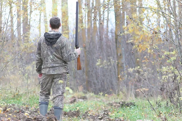 Homem em camuflagem e com armas em um cinto florestal em um hun primavera — Fotografia de Stock