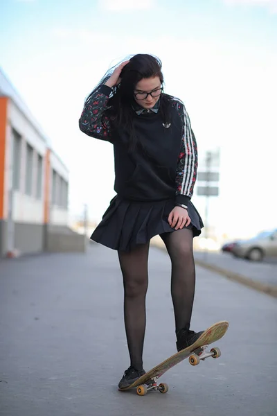 Ein junges Hipster-Mädchen fährt Skateboard. Mädchen Freundinnen f — Stockfoto