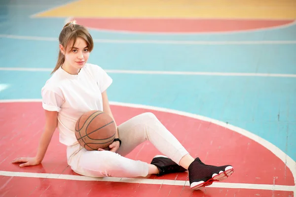 Menina no ginásio jogando uma bola de basquete — Fotografia de Stock