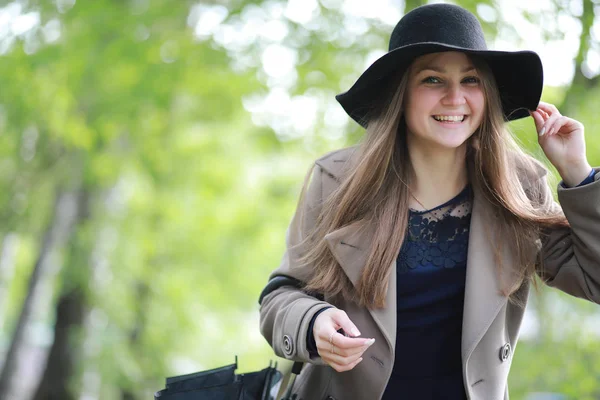 Jeune fille dans un manteau dans un parc de printemps — Photo