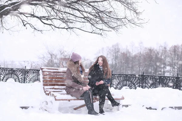 Chica en un parque de invierno en las nevadas —  Fotos de Stock