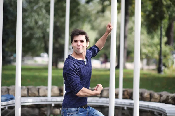 A young man walks in the park at lunch time. A man is on a walk