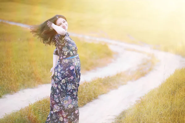 Gravid flicka i en klänning i naturen — Stockfoto