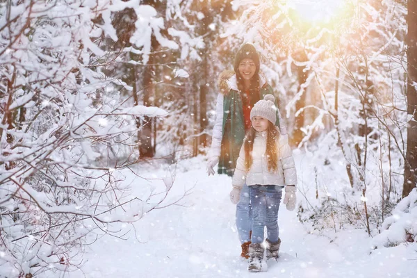 Una familia joven para dar un paseo. Mamá y su hija están caminando en un winte — Foto de Stock