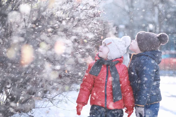 Les enfants marchent dans le parc première neige — Photo